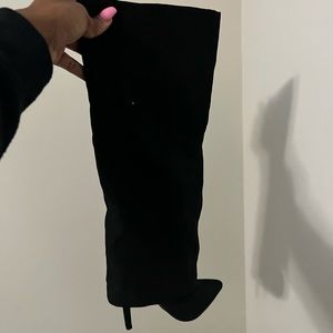 Black knee high heeled boots.